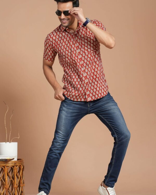 Man wearing red floral print cotton short-sleeve shirt with blue jeans