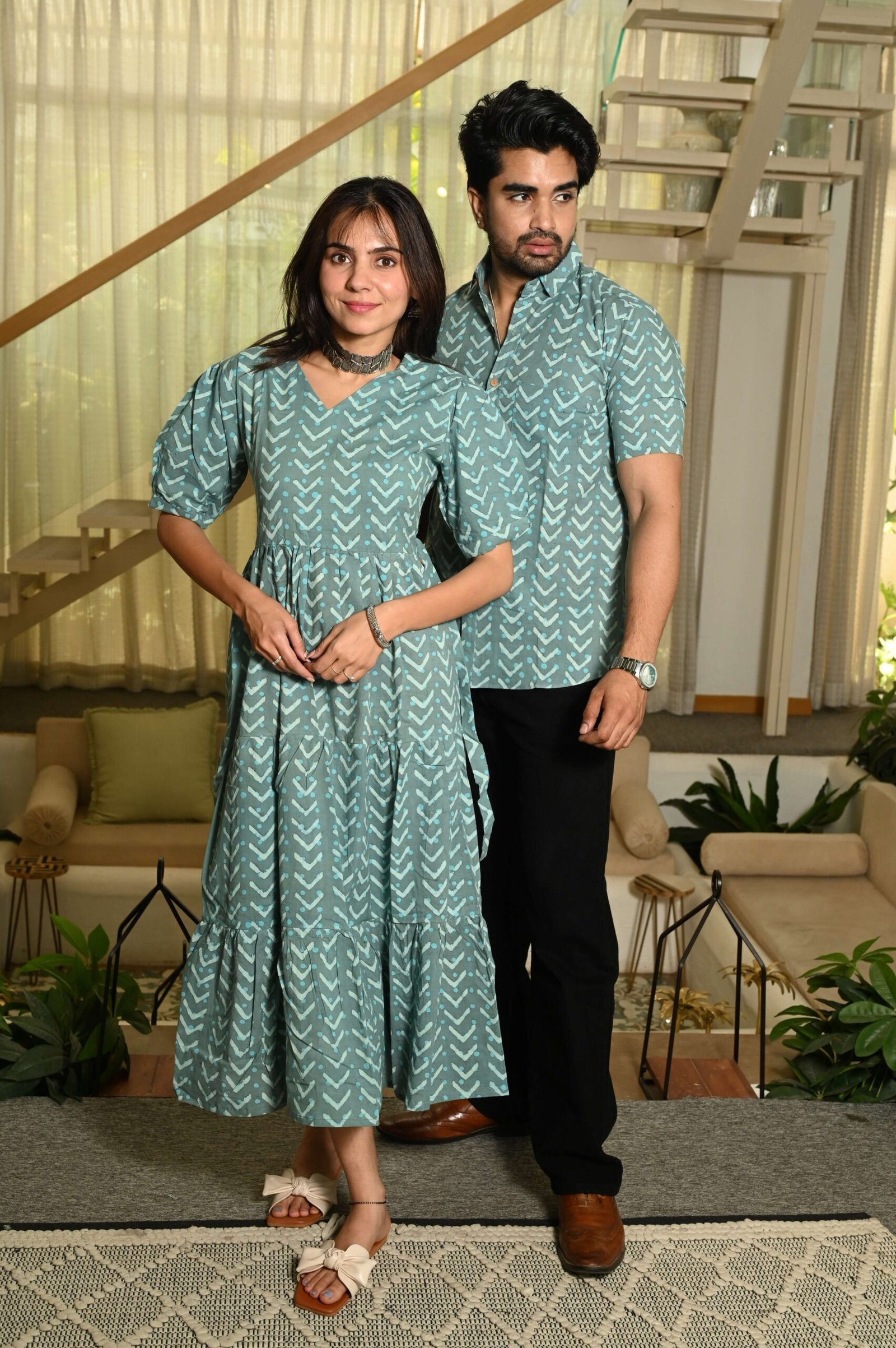Couple wearing matching sage green cotton dress and shirt with arrow print