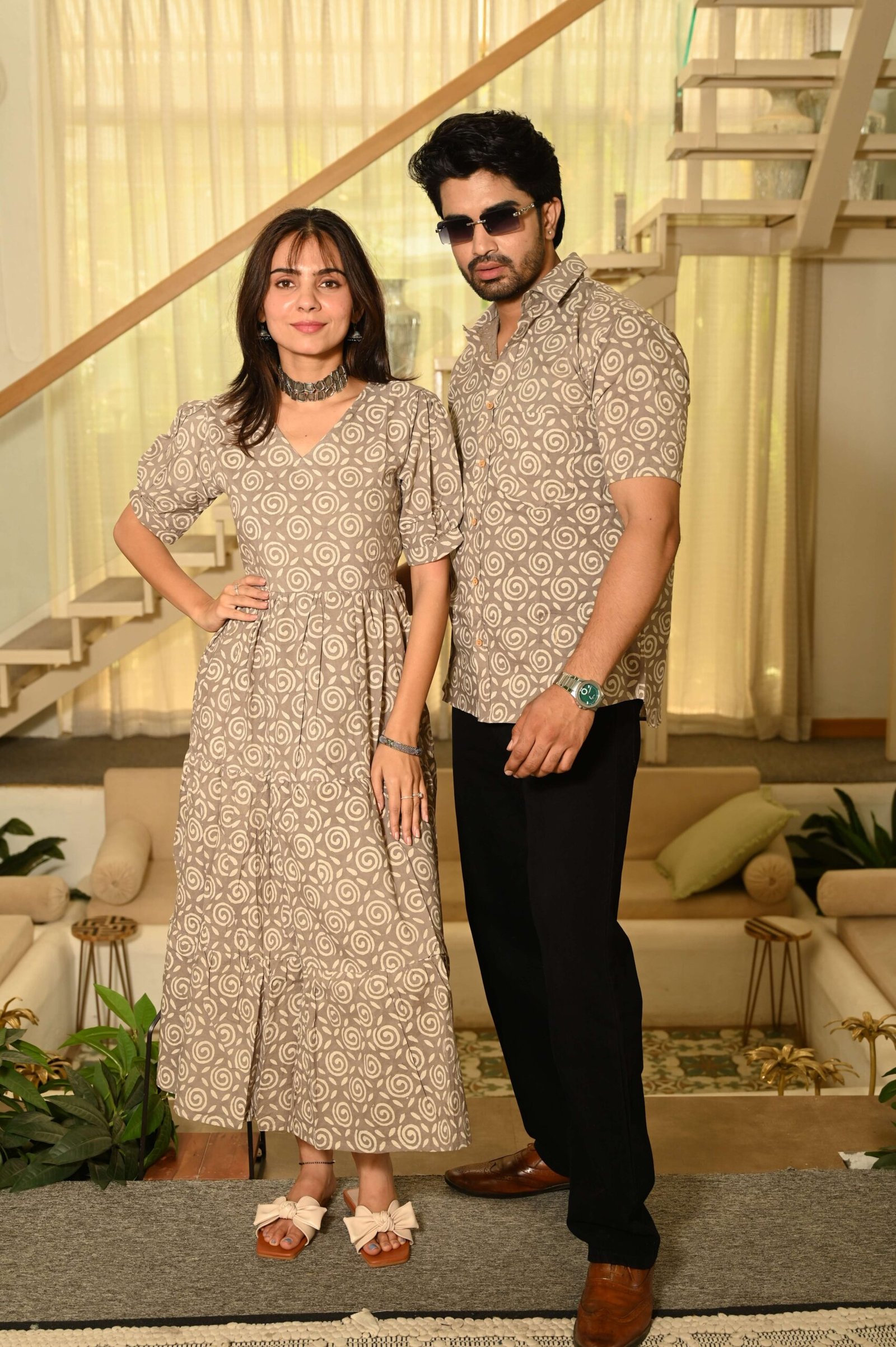 Couple wearing matching beige cotton dress and shirt with swirl block print