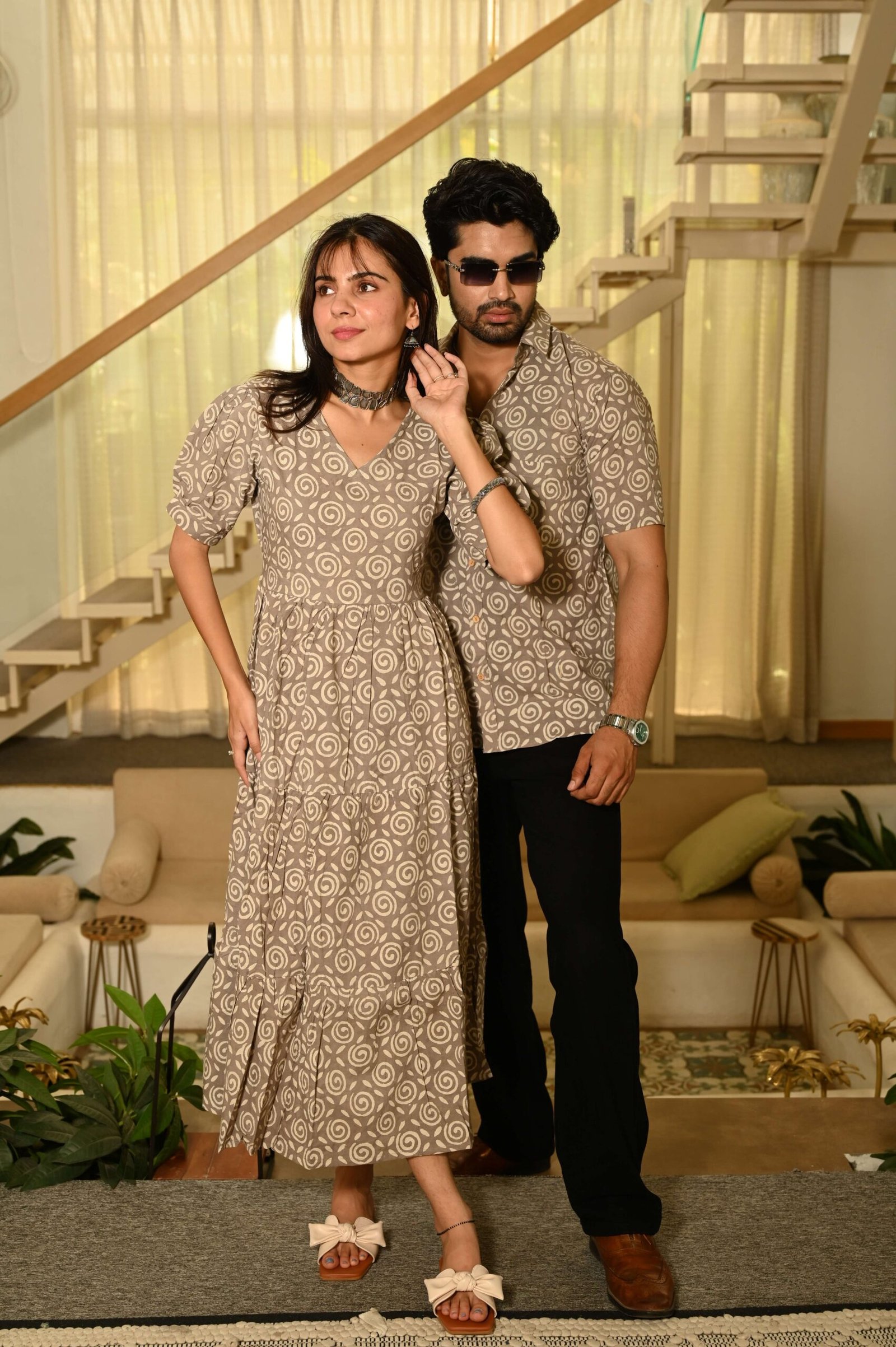 Couple wearing matching beige cotton dress and shirt with swirl block print
